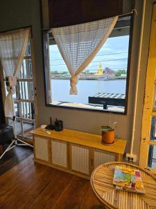 a room with a large window with a view of the water at เฉื่อยโฮมสเตย์ in Nonthaburi +9 photos