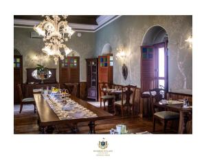 Un comedor con mesas y sillas y una lámpara de araña. en Rambha Palace, en Rambha