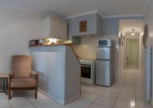 a kitchen with white appliances and a chair in a room at Gîte Nino Colombiers in Colombiers