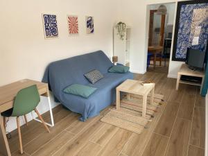 a living room with a blue couch and a table at Studio Solviou in Six-Fours-les-Plages
