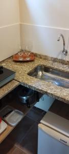 卢米亚PARAÍSO ROMÂNTICO - para casais - cozinha para preparar suas refeições的厨房柜台设有水槽和2个酒杯