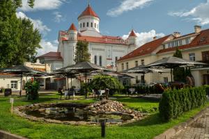 a building with a pond in front of it with umbrellas at Mabre Residence in Vilnius