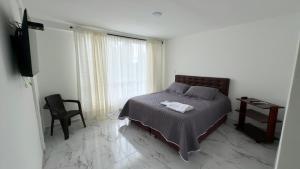 VillamaríaHospedaje Los Termales的一间卧室，配有一张床、一张书桌和一扇窗户 更多3张照片