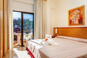 pokój hotelowy z łóżkiem z kwiatem w obiekcie Hotel Marquesa w Puerto de la Cruz
