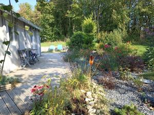 patio z krzesłami i kwiatami w ogrodzie w obiekcie Gîte Nature et détente w mieście Aubréville