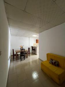 a living room with a yellow couch and a table at Apartamentos La Villa in Los Santos