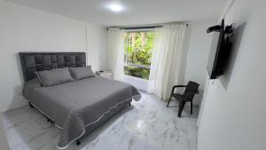 VillamaríaHospedaje Los Termales的带床和窗户的卧室