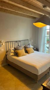 Un dormitorio con una cama grande con almohadas amarillas. en Lakeview Jonny house on the roofs, en Lezzeno