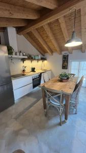 Una cocina con una mesa y sillas de madera en una habitación. en Lakeview Jonny house on the roofs, en Lezzeno