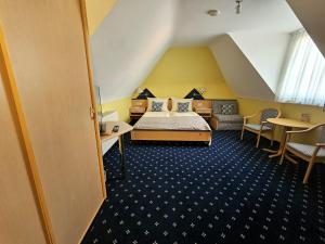 a hotel room with a bed and a table and chairs at Hotel Rüdesheimer Hof in Rüdesheim am Rhein