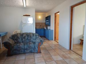 a living room with a couch and a refrigerator at Rus 'n Bietjie in Witsand