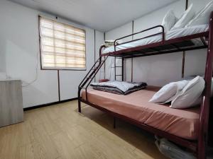 a bedroom with two bunk beds and a window at D'Maro Hut Mesilou in Kampong Kundassan