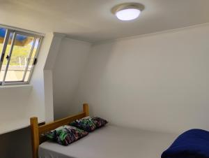 a bedroom with a bed and a window at Backpackers House - Near The Airport in Santiago