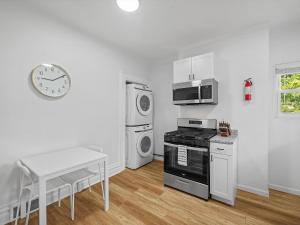 Schenley HeightsにあるBloomfield, Shadyside !A Modern and Bright Private Bedroom with Shared Bathroomのテーブルと壁に時計があるキッチン