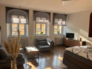 a bedroom with a bed and a chair and windows at Hinter der Alten Post in Annaberg-Buchholz