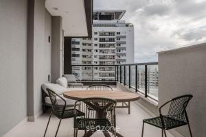 a balcony with a table and chairs and a couch at LGDs - Apartamentos no Centro de Florianópolis in Florianópolis