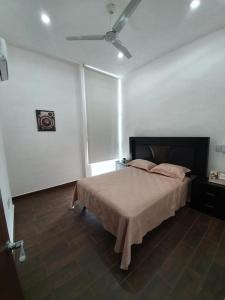 a bedroom with a bed in a white room at Coto arrecifes casa 67 in Mezcales