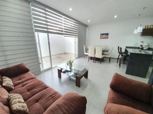 a living room with a couch and a table at Coto arrecifes casa 67 in Mezcales