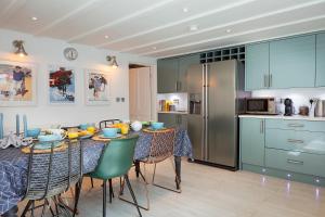 a kitchen with a table with chairs and a refrigerator at Flora Dora - Luxury cottage - modern - central - ideal for groups and families in Filey