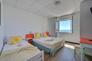 a room with two beds and a window at Hotel Camille in Saintes-Maries-de-la-Mer +54 photos