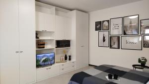 a bedroom with white cabinets and a tv on a wall at Braguti Apartments in Romano di Lombardia