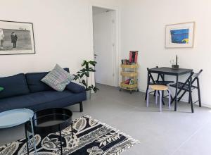 a living room with a blue couch and a table at Between Valley & Mountain in Yoqne‘am