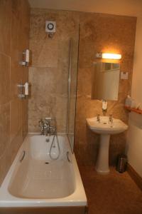 a bathroom with a bath tub and a sink at Royal Lodge in Symonds Yat