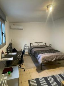 a bedroom with a bed and a desk and a desk at Simple Stay Vari's House in Vari