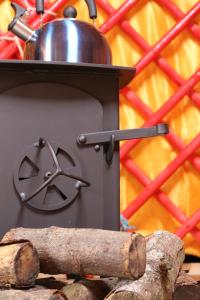 a pot on top of a stove with a log at Ettrick Valley Yurts in Yarrow