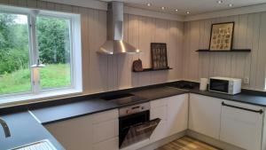 a kitchen with white cabinets and a microwave at Farmhaus in Sveg