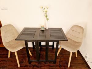 a table with two chairs and a vase with flowers on it at Helena Old Town Apartment in Košice