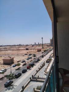 einen Balkon mit Blick auf eine Straße mit Autos in der Unterkunft Down Town in Dawwār Muḩammad Abū Shunaynah
