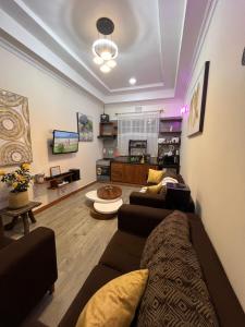 a living room with a couch and a tv at Lavish luxury homes in Nkoanrua