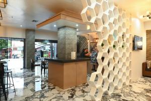 a lobby of a restaurant with a geometric wall at Lolita Heights Hotel in Tacloban
