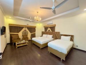 a hotel room with two beds and a tv at Dream Inn Guest House Islamabad in Islamabad