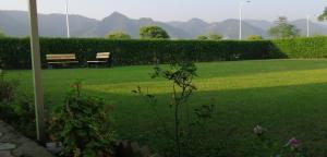 a park with a bench in a field of grass at Dream Inn Guest House Islamabad in Islamabad