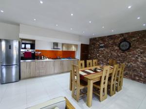 a kitchen with a wooden table and a stainless steel refrigerator at Luxury Seaview Apartment Flic en Flac ASF4 in Flic-en-Flac