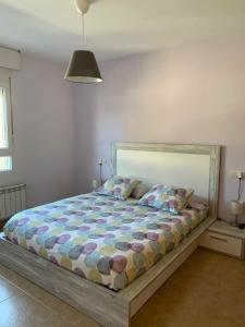 a bedroom with a bed with a colorful comforter at Casa Chocolate in San Miguel del Pino
