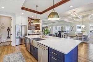 an open kitchen with blue cabinets and a large island at 3 Shore Crest Lane- Chefs Kitchen, Game Room, Near Beach, Private Pool, FREE Activities Included in Hilton Head Island
