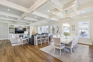 a dining room and living room with a table and chairs at 3 Shore Crest Lane- Chefs Kitchen, Game Room, Near Beach, Private Pool, FREE Activities Included in Hilton Head Island