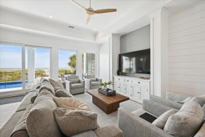 a living room with a couch and a flat screen tv at 3 Singleton Beach - Oceanfront Estate, Private Pool, Elevator, FREE Activities Included in Hilton Head Island