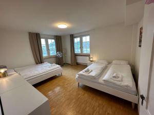 a room with two beds and two windows at HITrental Limmatquai Apartment in Zürich