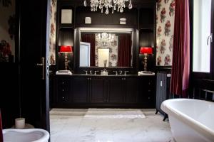 a black bathroom with a sink and a mirror at La Maison du Théâtre in Ravenna +13 photos
