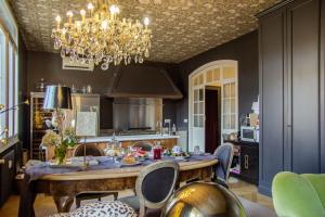 a kitchen with a table and chairs and a chandelier at La Maison du Théâtre in Ravenna