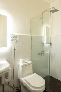 ein Badezimmer mit Toilette und Glasdusche in der Unterkunft Homey and Cozey Poblacion Makati S10 in Manila + 10 Fotos