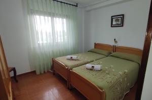 a bedroom with a bed with two candles on it at Pensión Casa Vicente in Tineo