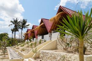 珀尼达岛Sun Grace Penida Cottage的通往一座有棕榈树的建筑物的楼梯