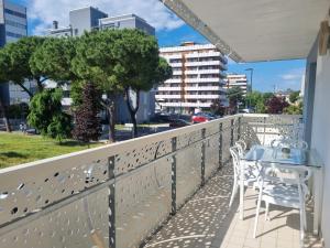 a patio with a table and chairs on a balcony at Aparthotel Holiday in Lignano Sabbiadoro