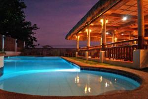 a swimming pool at night with a gazebo at Kav's Beach Resort in Zamboanguita