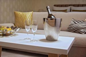 a bottle of champagne and two wine glasses on a coffee table at Privilege - EMPIRE Hotels Group in Košice